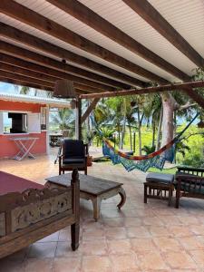 a porch with a hammock and a patio with a swing at Villa Les Trois Moulins in Saint-François