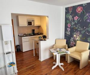 a small kitchen with a table and chairs in a room at Apartment-Hotel Perle am Bodden in Ribnitz-Damgarten +71 photos