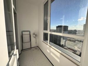 a room with two windows and a view of a city at Уютная квартира в ЖК Республика in Astana