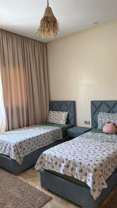 a bedroom with two beds and a chandelier at Villa Azoul in Tiguemmi n Oumzil et Tnine