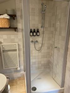 a shower with a glass door in a bathroom at Stylish Loft Apartment on a Country Farm in Bad Fallingbostel