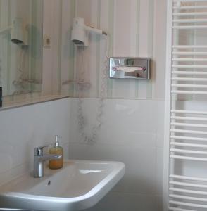 a white bathroom with a sink and a mirror at Privatpension Waldbröl in Waldbröl +18 photos