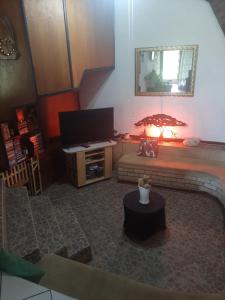 a living room with a table and a television at AD'S Overnight Accommodation in Richards Bay