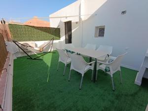 a table and chairs on a balcony with green grass at Luz de Calma in Tabernas