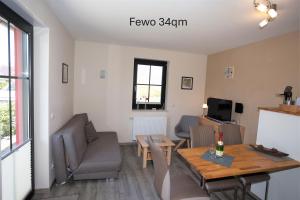 a living room with a table and a couch and a dining room at Ferienhaus Am Pappelwald in Glowe +29 photos