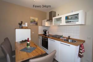 a small kitchen with a wooden table and a sink at Ferienhaus Am Pappelwald in Glowe