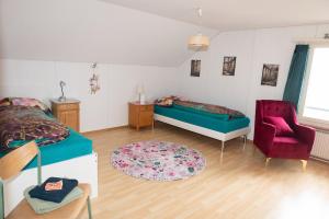 een slaapkamer met een bed, een bank en een stoel bij BnB Ilfis Wohnung Nr 2 in Langnau