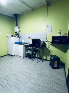a room with a kitchen with a table and a refrigerator at Departamento interior amoblado 2 personas in Temuco