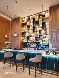 a restaurant with a bar with three stools in front at Vida Marassi Marina Two Bedroom Hotel Apartment in El Alamein +35 photos