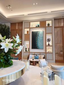 a living room with a couch and a table with white flowers at Vida Marassi Marina Two Bedroom Hotel Apartment in El Alamein