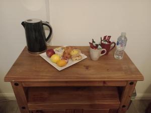 ein Holztisch mit einem Teller Obst darauf in der Unterkunft The Paddock Side in Uttoxeter