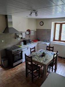 a kitchen with a table with chairs and a stove at Les VIGNEAUX Hautes Alpes, Appartement 4 personnes, avec belle terrasse panoramique in Les Vigneaux