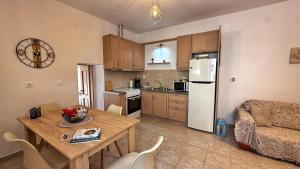 a kitchen with a table and a white refrigerator at Madou house in Leonidio