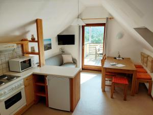 a small kitchen with a table and a microwave at Ferienhof Seeblick in Buchberg bei Herberstein