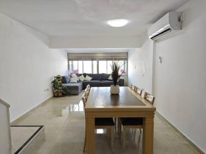 a living room with a table and a couch at קסם הכנרת in Tiberias