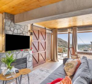 a living room with a couch and a tv at LA MADRIGUERA De FUENTE HERVERA in Las Lagunetas
