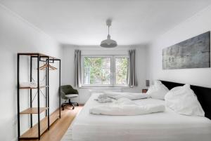 a white bedroom with a large bed and a window at Stilvolle Apartments mit Kamin - Schlossblick und großer Terrasse 2-4 Zimmer 50-140qm - nahe A1 und Schloss Burg - Köln in Solingen