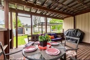 a patio with a table and chairs on a deck at Cozy cottage by the beach in Pointe-du-Chêne
