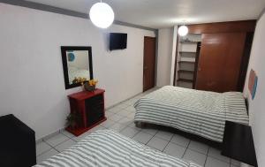 een kleine slaapkamer met twee bedden en een spiegel bij Sol viajero Guadalajara in Guadalajara