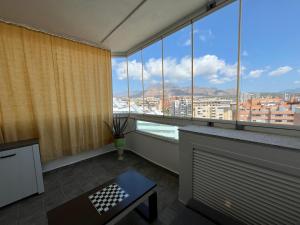 a room with a large window with a view of a city at Benidorm Ambra in Villajoyosa