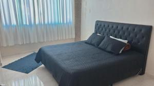a bedroom with a bed with a blue comforter at A Casa Azul in Peruíbe +19 photos