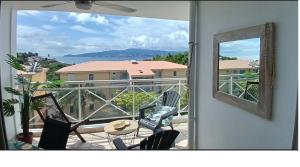 a view of a balcony with chairs and a table at T2 vue mer panoramique, 3 ilets in Les Trois-Îlets