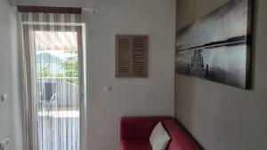 a living room with a red couch and a window at Apartman Bilandžić Drage in Drage