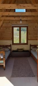 a room with two beds and a window in a cabin at Highland Cabins Krnja Jela in Šavnik