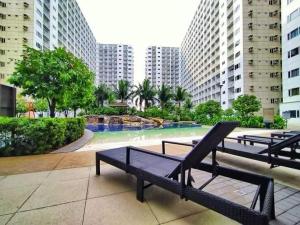 a group of benches in front of a swimming pool at Hotel De Rama Unit 1230 near MOA & NAIA in Manila
