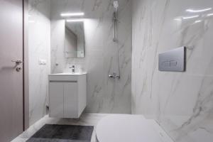 a white bathroom with a toilet and a sink at Marios Suite Corfu in Corfu