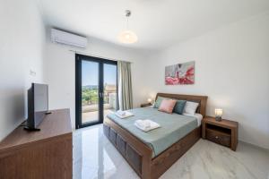a bedroom with a bed and a flat screen tv at Marios Suite Corfu in Corfu +22 photos