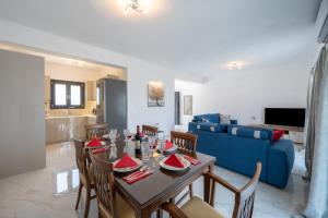 a dining room with a table and chairs and a blue couch at Marios Suite Corfu in Corfu