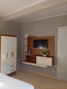 a bedroom with a flat screen tv on a wall at Apto 11 bom preço benefício in Brasilia