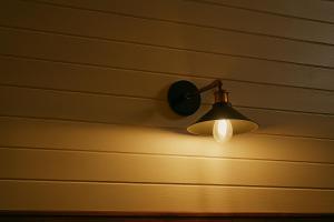 a lamp on the wall of a house at La Râu - Căsuța de sus in Cîmpulung