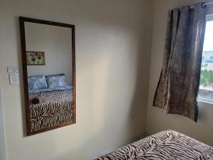 a mirror in a room with a bed and a window at Apart próximo a Unimed de 2 quartos com Ac e garagem in Santo Ângelo