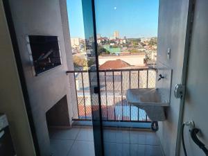 een badkamer met uitzicht op een balkon met een wastafel bij Apart próximo a Unimed, Catedral, HSA com 2 Ar e garagem in Santo Ângelo +35 foto's