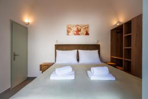 a bedroom with a large bed with two white pillows at The Lemon Tree House in Fira