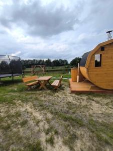 a wooden cabin with a table and a picnic table and a tent at Sielanka in Wielgie +13 photos