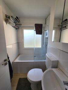 a bathroom with a tub and a toilet and a sink at Gemütliche Einzimmerwohnung in Künzelsau +7 photos
