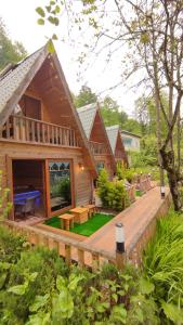 a large wooden house with a deck and a piano at ELASYA BUNGALOV in Rize