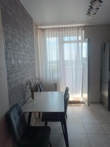 a dining room with a table and chairs and a window at Квартира Одесская in Odesa