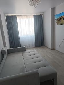 a living room with a bed and a window at Квартира Одесская in Odesa