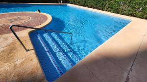 a blue swimming pool with a metal rail next to it at Benidorm Ambra in Villajoyosa