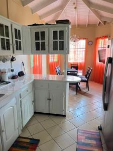 a kitchen with white cabinets and a table at Fano's Oasis in Castries