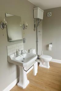 a white bathroom with a sink and a toilet at Luxury 4-Bedroom 2 Bathroom Private Vila in Loanhead