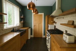 a kitchen with a sink and a stove top oven at Luxury 4-Bedroom 2 Bathroom Private Vila in Loanhead +14 photos