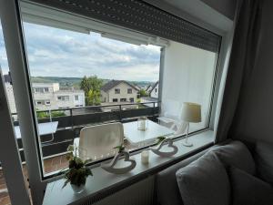 a room with a large window with a table and chairs at Ferienapartment Zeit am See in Körbecke