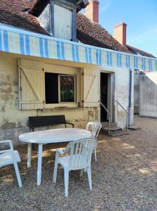 a table and two chairs sitting under a awning at Maison de campagne in Saint-Bonnet-Tronçais +16 photos