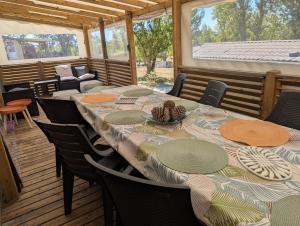 ein Esszimmer mit Tisch und Stühlen auf einer Terrasse in der Unterkunft Mobil home Apollon Riviera in Saint-Papoul