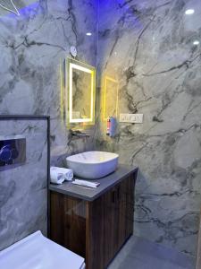 a bathroom with a sink and a marble wall at Hotel Savaya Luxury Stay Near AIIMS Rishikesh in Rishīkesh